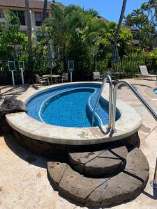 a swimming pool with a rock around it at Lanai Villas in Koloa