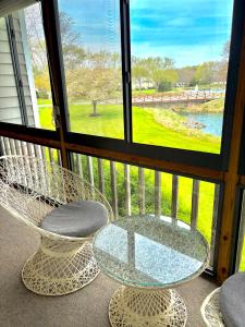 a balcony with a table and two chairs and a window at Elegant 3-Bedroom Condo in Lewes with Pond Views in The Plantations