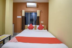 コルカタにあるHotel O Palki Palace Near Netaji Subhash Chandra Bose International Airportのベッドルーム1室(赤い枕のベッド1台、窓付) +44枚の写真