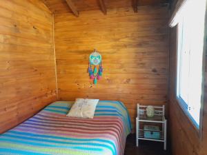 a bedroom with a bed in a wooden cabin at cabaña cuatro reinas in Tigre