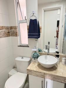 a bathroom with a toilet and a sink at Apto completo com ar, piscina 2 quartos in Camaçari +2 photos