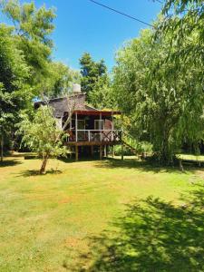 ein Haus inmitten eines Hofes mit Bäumen in der Unterkunft cabaña cuatro reinas in Tigre