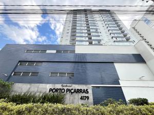 un bâtiment avec une enseigne sur le côté dans l'établissement Residencial Porto Piçarras - Itacolomi, à Balneário Piçarras
