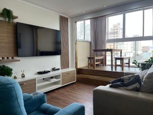 - un salon avec un canapé et une grande télévision dans l'établissement Residencial Porto Piçarras - Itacolomi, à Balneário Piçarras