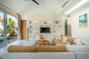 a living room with a couch and a tv at Villa Casa Blanca, Bingin Beach in Uluwatu