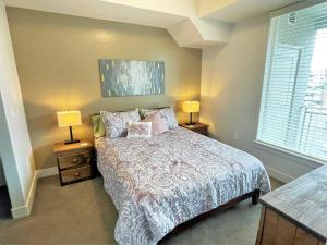 a bedroom with a bed and two lamps on tables at Luxury Condo in the Library Square District in Salt Lake City