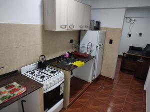a kitchen with a stove and a sink and a refrigerator at Mercedita in Humahuaca