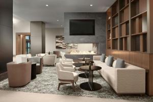 雷斯顿AC Hotel by Marriott Reston的大堂配有沙发、椅子和壁炉