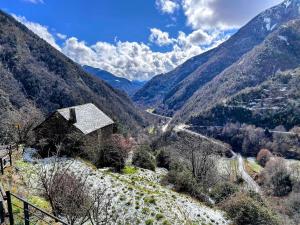 a view of a mountain valley with a house on a hill at Casa Rústica y Chic con Chimenea y Vistas Panorámicas de La Vall de Boí in Cardet +58 photos