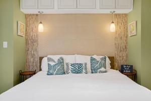 a bedroom with a bed with blue and white pillows at Remodeled 1BR at Kihei Ali'i Kai with Free Parking! in Kihei +62 photos