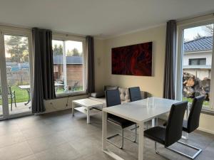 a dining room with a white table and chairs at 1-bedroom apartment in Hangelsberg