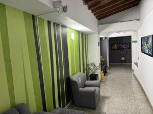 a hallway with green and white stripes on a wall at Hotel JC 43 in Medellín