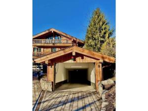 a large wooden house with a large garage at Holiday apartment Bergliebe on Lake Tegernsee in Rottach-Egern
