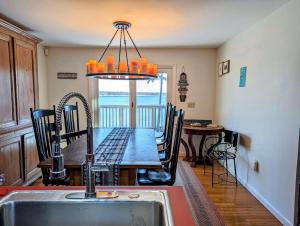 una cucina con tavolo, sedie e lavandino di Oceanfront Crackling Cove Cottage Family firer pit slleeps 6 a Gouldsboro