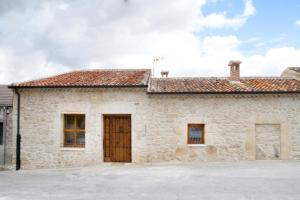 a large stone house with a wooden door at Casa de Laura in Aldeasoña