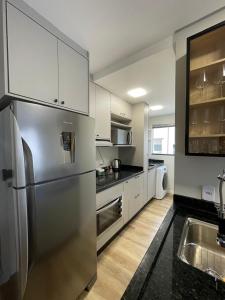 a kitchen with a stainless steel refrigerator and a sink at Konell Apartment 205 in Pomerode +9 photos