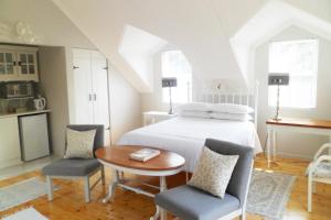 a bedroom with a bed and a table and chairs at Kastelein Guesthouse in Pongola +20 photos