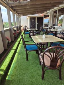 a patio with tables and chairs on the grass at Noura Suites in Ukunda