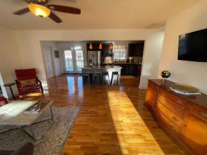 a living room with a table and a kitchen with a ceiling fan at Travel Often House in Kennesaw
