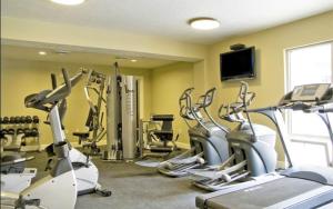 un gimnasio con varias máquinas de correr y TV de pantalla plana en 3-Bedroom Luxury Condo in the Heart of the City, en Salt Lake City