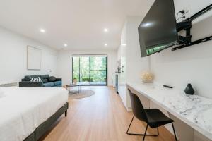 a bedroom with a bed and a living room at Tree Top Treasure Itas in Kings Meadows