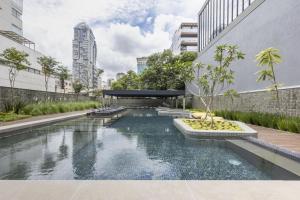 a pool in the middle of a city with buildings at VN Millennium Faria Lima in São Paulo