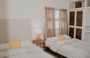une chambre avec deux lits et une lampe sur une table dans l'établissement Apartamento Benitez 301 by Zakher, à Carthagène des Indes