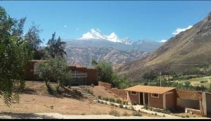 una casa en un campo con una montaña en el fondo en Villa Buenaventura, en Caraz