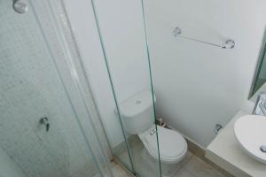 a bathroom with a toilet and a glass shower at Apartamento Benitez 301 by Zakher in Cartagena de Indias +37 photos