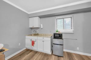 a kitchen with white cabinets and a sink at Family-Friendly Room for 4 – High-Speed Wi-Fi in Woodhaven