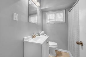 a white bathroom with a sink and a toilet at Family-Friendly Room for 4 – High-Speed Wi-Fi in Woodhaven