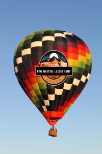 a colorful hot air balloon flying in the sky at RUM MARTINA lUXURY CAMP in Wadi Rum
