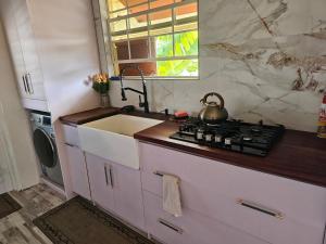 a kitchen with a sink and a tea kettle on a stove at Harvey's Mizpahcot Oasis - Cruise Port, Us Embassy and Vacation in Bridgetown