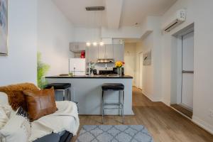 a living room with a couch and a kitchen at Snug Studio on Bishop DT MTL in Montréal