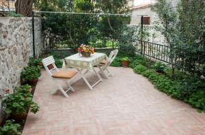 Un patio con una mesa con dos sillas y flores. en Apartments Leo, en Split
