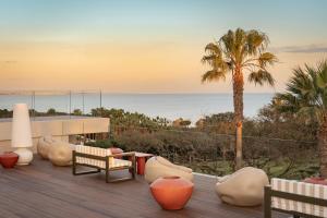 a deck with furniture and a view of the ocean at Kimpton Atlantico Algarve by IHG in Albufeira