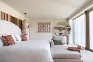 a bedroom with a white bed and a couch at Kimpton Atlantico Algarve by IHG in Albufeira