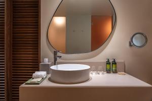 a bathroom with a round sink and a mirror at Kimpton Atlantico Algarve by IHG in Albufeira