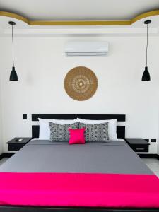 a bedroom with a large bed with a pink blanket at Villa del Mar Hotel Boutique in Cahuita +74 photos