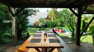 a long wooden table sitting on a patio at Beachfields Bungalows in Balian