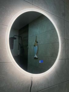 a round mirror on a wall with a vase in it at Luxury Penthouse in Puntacana 2 in Punta Cana +17 photos