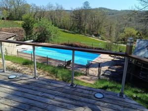 a view of a swimming pool from a deck at Chalet rustique au Périgord Noir avec terrasse et équipements inclus - FR-1-616-57 in Saint-Pompont