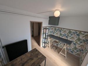 a living room with a table and a wall at Appartement verdoyant au bord du lac Leman entre Evian et Thonon dans une Villa in Publier