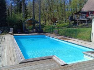 a large blue swimming pool with a wooden deck at Maison de charme avec jardin clos et Wifi au cœur du Périgord Noir - FR-1-616-401 in Saint-Pompont