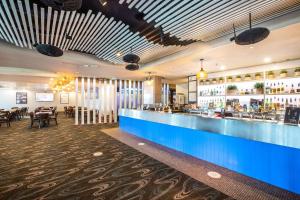 a restaurant with a blue counter and a bar at Narrabeen Sands Hotel by Nightcap Plus in Narrabeen