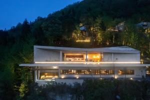 een groot wit huis met lichten aan bij The Mount Route 上山上-抱翠 in Shuang-ho