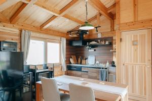 a kitchen with a table and chairs in a cabin at One ペットと泊まれるログハウス in Oyodo