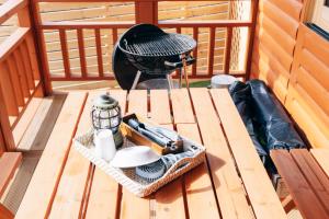 a picnic table with a grill on a deck at One ペットと泊まれるログハウス in Oyodo