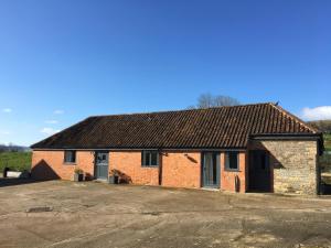 a red brick house with a driveway in front at Swallows Nest in Sturminster Newton