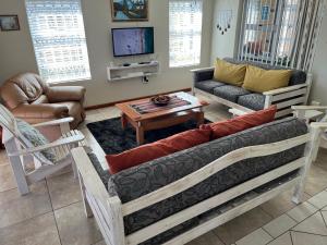 a living room with a couch and a table at Calamari Self Catering in De Kelders
